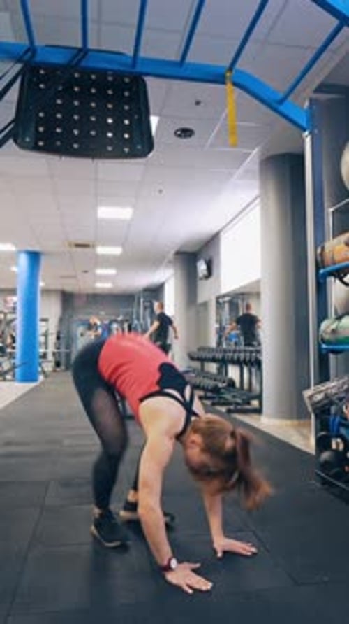 Active girl in fitness gym. Beautiful muscular fit woman exercising in gym