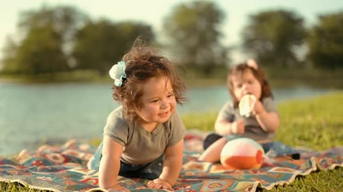 Twin Babies Seating and Playing in the Lake