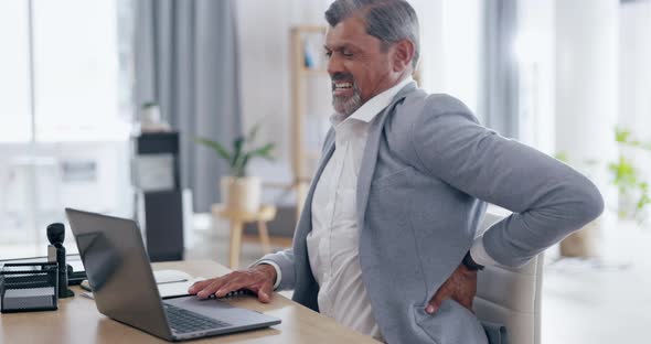 Laptop, back pain and senior businessman at his desk with muscle injury ...