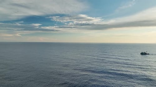 Luftaufnahme: Fischereifahrzeug am Horizont nähert sich dem Hafen