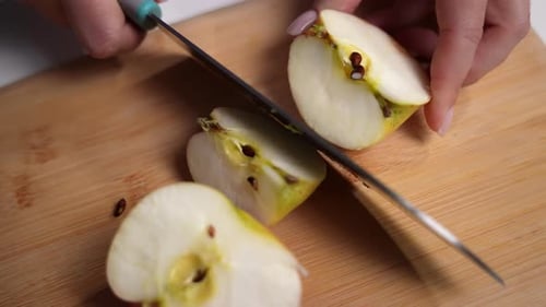 Hands Slicing Fresh Apple on Cutting Board