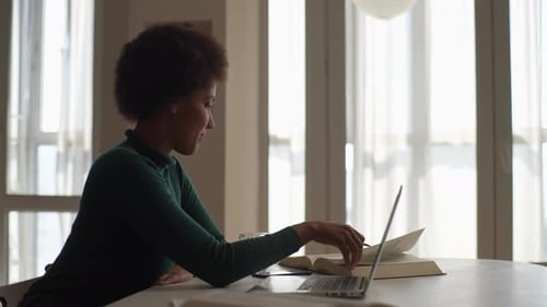 Side View of Pretty AfricanAmerican Female Student Studying Online From Home Watching Web Class