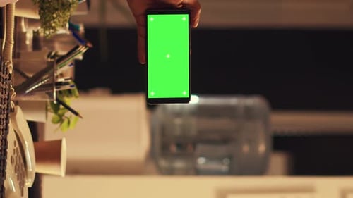 Woman Working Behind Phone with Green Screen at Night