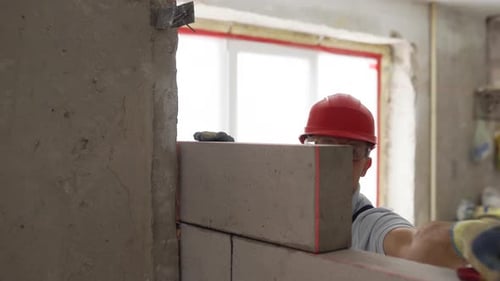 Man Building a Block Wall Inside