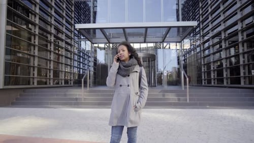Businesswoman in Casual Clothing Talking in Phone on the Big City Street in the Business District
