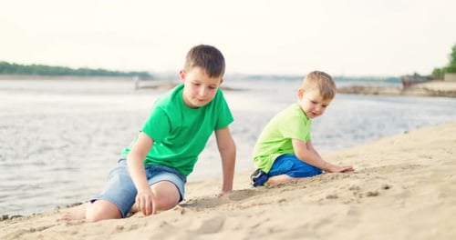Kids Playing with Sand on Sea Beach in Warm Sunshine in the Summer