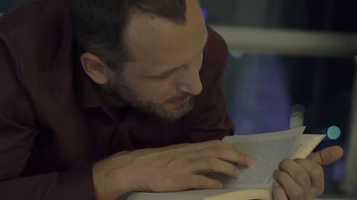 Man Reading Book Late at Night
