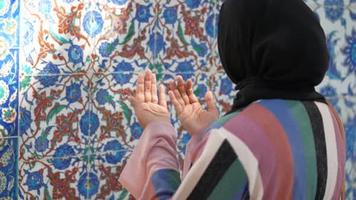 Muslim Young Woman in Hijab is Praying in Mosque