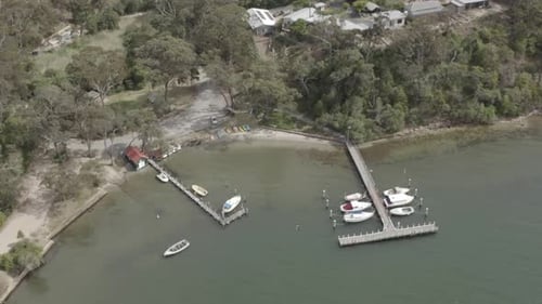 A small port with some boats seen from the sky flying along the coastline from Australia. Beaches an