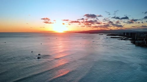 Peaceful waterscape of the Pacific Ocean at the coast of Hawaii. Sun sets behind the horizon.