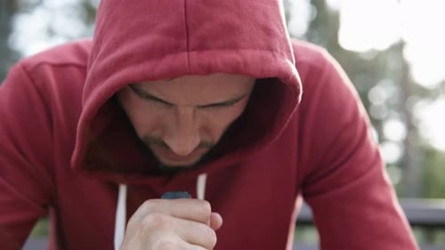 A man with alcohol addiction in a depressed state holds a bottle of wine in his hands.