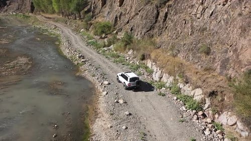 Aerial View Of Offroad Vehicle Driving By The Creek