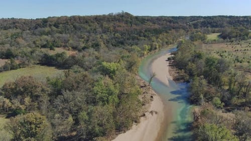aerial view along a winding river toward the hillside