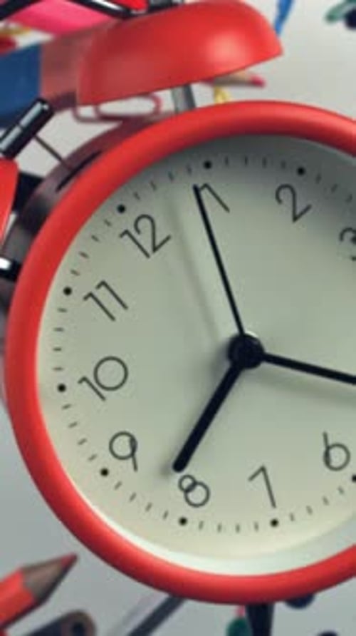 An Alarm Clock with Various School Supplies Flies Up and Falls Filmed on a Highspeed Camera at 1000