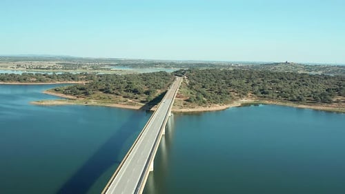 Standbild einer Balkenbrücke, die einen Schatten ins Wasser wirft