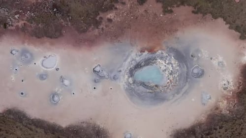 Aerial at field with multiple active volcanic mudpots in Iceland