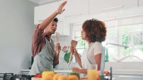 Joyful Couple Singing and Dancing in Kitchen