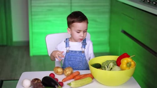 Young Boy at Kitchen Table with Fresh Vegetables