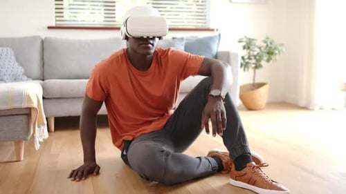 Man Wearing VR Headset Sits on Living Room Floor