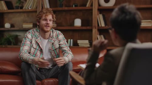 Man Talking With Therapist on Couch in Office
