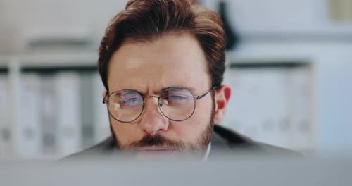 Man Wearing Glasses Working at a Computer