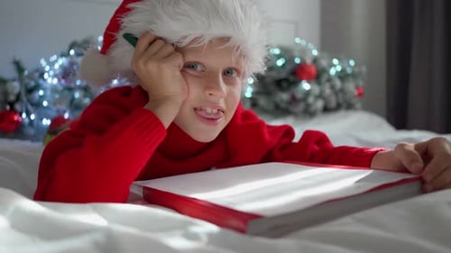 Boy Writes Christmas Letter in Decorated Room