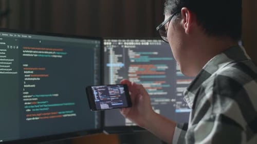Programmeur regardant la base de données sur un smartphone lors de la création d'une Appli de développement d'un ingénieur logiciel