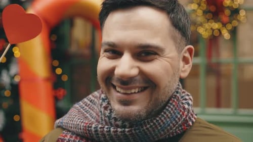 Man Holding Heart Shapes With Christmas Decorations