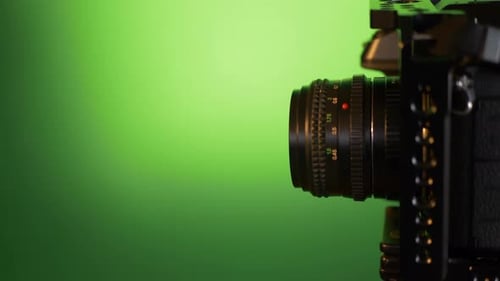 Modern mirrorless camera with vintage lens slide in to frame. Filmed in studio with atmospheric ligh