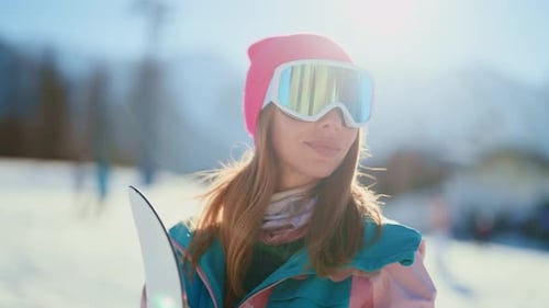 Woman with Snowboard on Sunny Winter Mountain