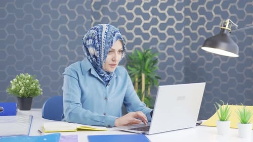 Frustrated hijab business woman on laptop.