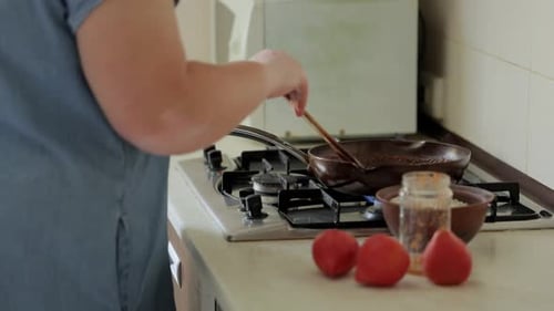 Woman Stirring Food in Pan with Spatula