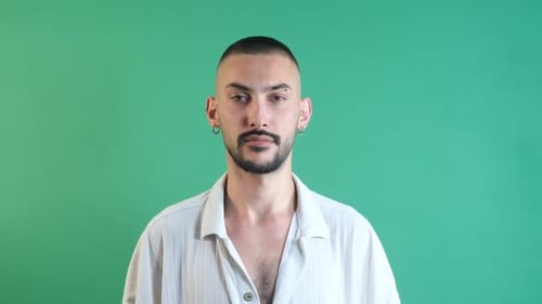 Young Man Stares Blankly at Camera on Green Screen