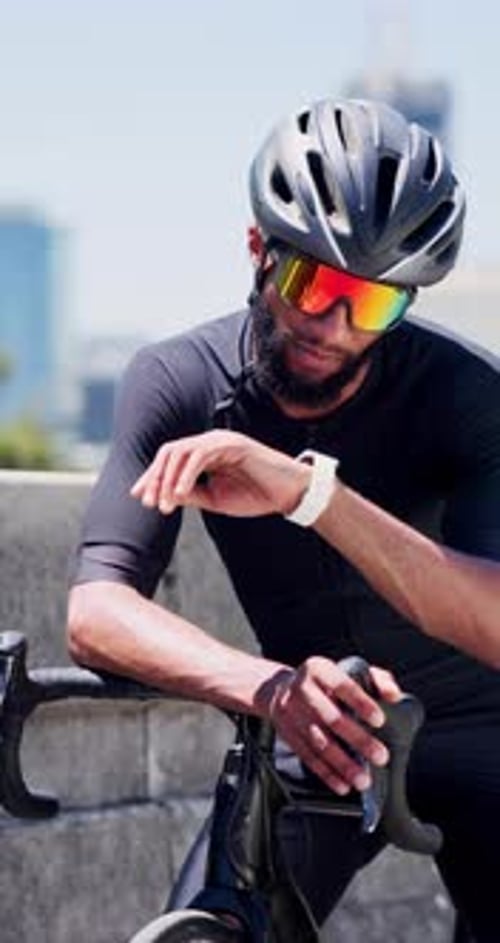 Black man, bicycle and smart watch in city for training with timer, thinking