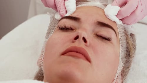 Client Skin Preparation for Cosmetic Procedure Patient Lying with Closed Eyes While Professional
