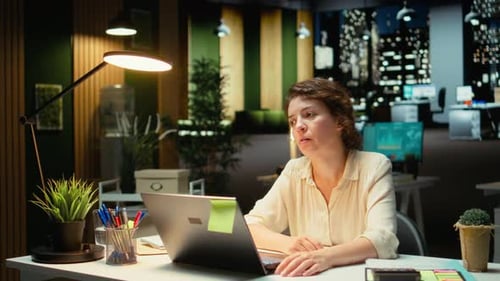 Woman works late at computer in office