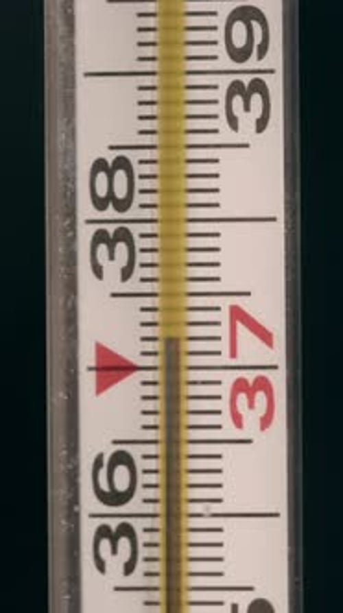 Frau hält Quecksilberthermometer in ihren Händen, um die Körpertemperatur zu messen, Arzt oder Krankenschwester