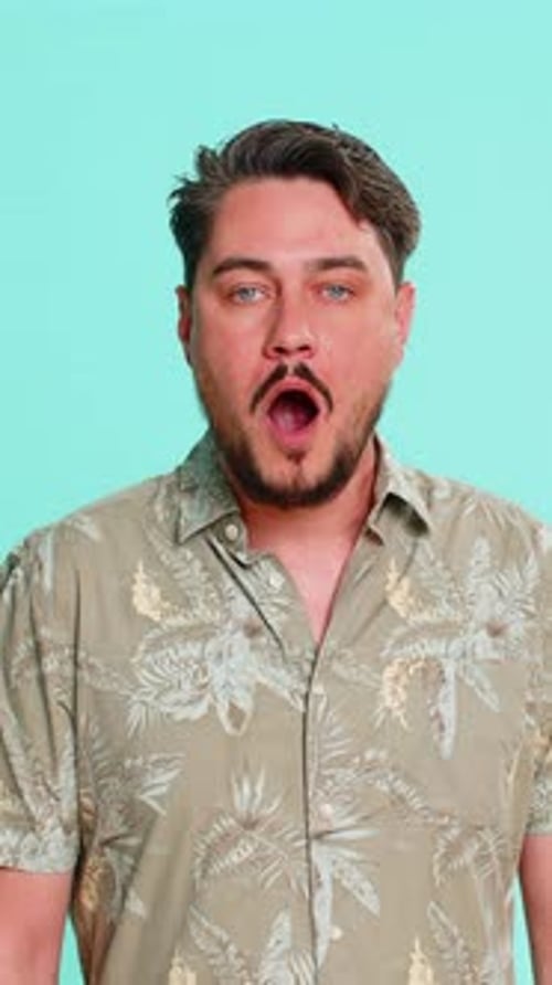 Shocked man with mouth open stands in studio