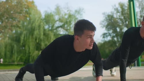 Athletic Men Doing Push-Ups in the Park