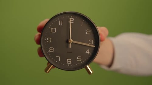 An Elegantly Designed Modern Alarm Clock Displayed Against a Striking Green Background