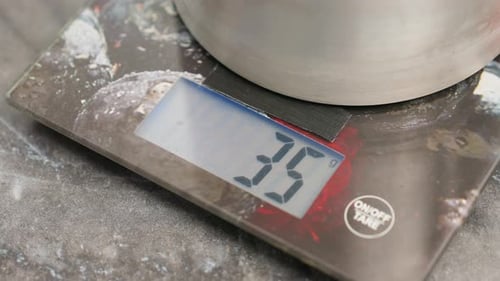 Close Up of Digital Weighing Scale with Metal Container on Countertop