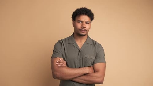 Disagreeing Young Man Shaking Head in Beige Studio