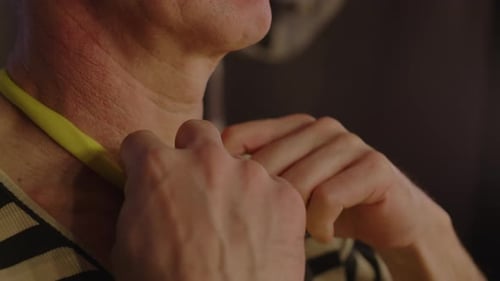 Adult Tying Yellow Scarf Around Neck