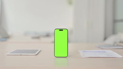 Smartphone with Green Screen on Desk in Office