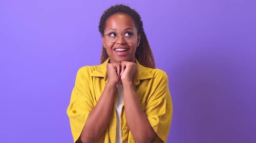 Woman Looking Upwards With Hands Clasped Under Chin