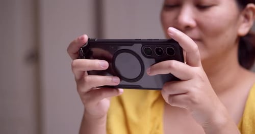 Young Adult Using Modern Smartphone for Mobile Gaming