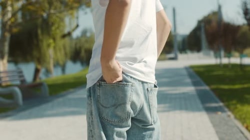 Rear View of Young Man in Casual Attire with Hand in Pocket Outdoors