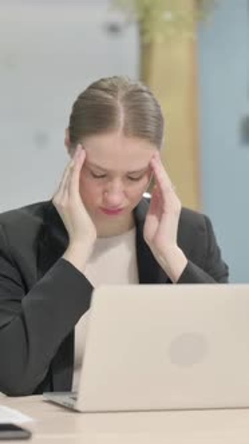 Businesswoman at Desk Suffering from a Headache