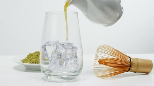 Matcha Green Tea Cooking Process Japanese Powder Green Tea in a Bowl with Bamboo Whisk Macro Close