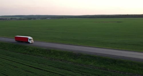 The Truck is Driving on the Highway at Sunset Drone View